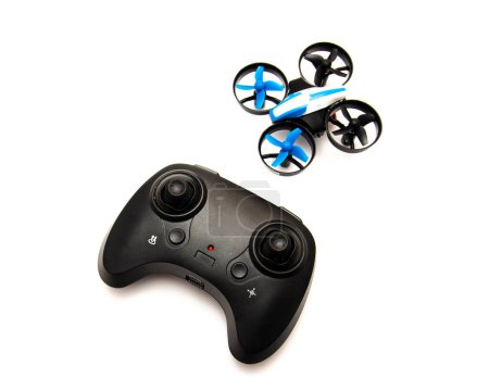 Indoor mini drone with joystick remote control radio, protection guard for propellers isolated on white background, quadcopter auto hovering and flashing light indicator, toy for kids. Education