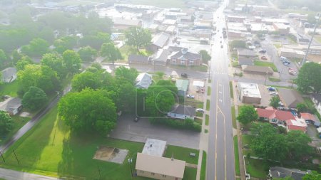 Historic downtown Checotah in McIntosh County, Oklahoma with row of antique malls, brick buildings, restaurants and suburb houses along Gentry Avenue, aerial view small town early morning light. USA