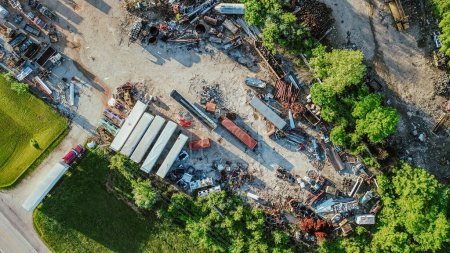 Row of container and variety of vehicle parts, scrap metals at large recycling center, Mountain Grove MO, ferrous nonferrous trash, old appliance, copper, electronic, environmental risks, aerial. USA
