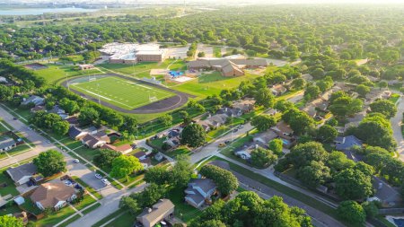 Saftig grüne Vorortsiedlung Reihe von Einfamilienhäusern, hohe Bäume, Fleck komplexe Fußballplatz, Tennisplätze, Spielplatz der Mittelschule in Dallas Fort Worth Vororte, Antenne. USA