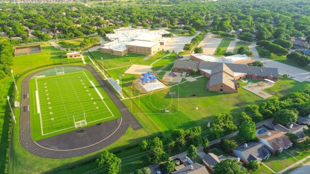 Tennis court, football field yard line marking, playgrounds of middle elementary school complex in upscale residential neighborhood lush green tree suburbs Dallas Fort Worth Metro complex, aerial. USA