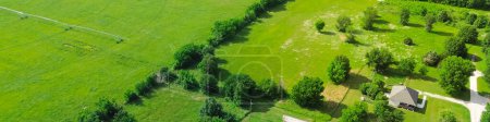 Panorama aerial view group of farmhouses on large lot size acre lush green trees, storage sheds and large farmland, pond system in Fairland, Oklahoma, rural American industry grassy field. USA