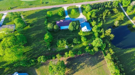 Large acreage rural lots with farm house and pond along service country road in Mountain Grove Missouri, farmland and ranches in the Midwest peaceful countryside agricultural area, aerial view. USA