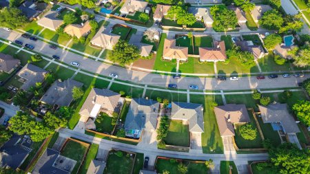 Curved residential streets with back-alleys, row of single-family houses with large backyard, grassy lawn in suburbs Dallas Fort Worth metro complex, suburban homes swimming pool, aerial view. USA