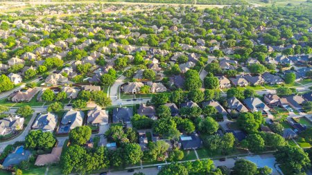 Dallas suburbs and urban sprawl with row of single-family houses fenced backyard, grassy lawn in subdivision outside DFW metro complex, upscale suburban homes with swimming pool, aerial view. USA