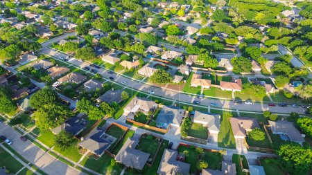 Medium density subdivision with parallel residential streets and back alleys, row of single-family houses lush green trees in suburbs Dallas Fort Worth metro complex, swimming pool, aerial view. USA