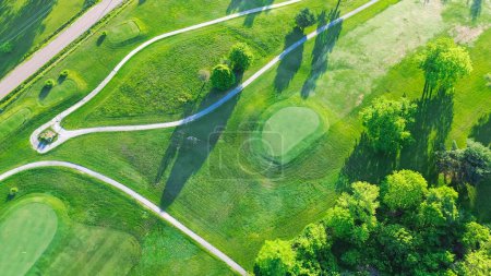 Chemin de chariot à vue aérienne droit dans un parcours de golf de 18 trous, somptueux fairways verdoyants en pente, beaucoup d'arbres au country club municipal de Mountain Grove, Missouri, prairie gazonnée pittoresque décontractée. États-Unis