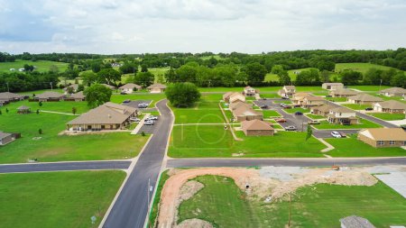 New development neighborhood with community center and row of brand-new houses at Wyandotte, Ottawa County, Oklahoma, suburban residential part of Joplin Missouri metropolitan, aerial view. USA