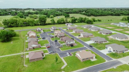 Fila de nuevas casas de desarrollo exuberante vegetación tierras de cultivo en Wyandotte, pequeño pueblo en el condado de Ottawa, Oklahoma, barrio residencial suburbano parte del área metropolitana de Joplin Missouri, aérea. Estados Unidos