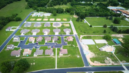 Neue Entwicklung Nachbarschaft Reihe von zweistöckigen Häusern neben öffentlichen Park im Bau Splash Pad, Basketballplatz, Pavillon Außenanlagen Wyandotte, Ottawa County, Oklahoma, Luftaufnahme. USA