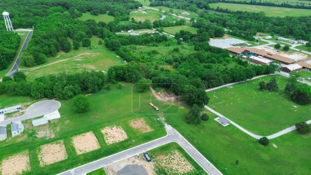 Aerial view cemetery in rural countryside area of Wyandotte, Ottawa County, Oklahoma, next to public park under construction and new developments houses neighborhood, lush greenery small town. USA