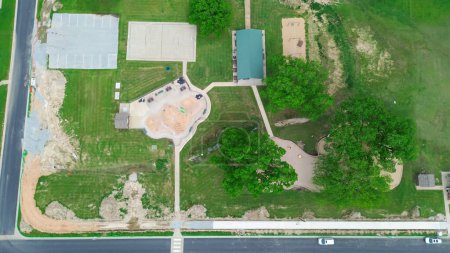 Suburban park under construction with splash pad, basketball courts, parking lots, pavilion shelter, public outdoor facilities in Wyandotte, Ottawa County, Oklahoma, Missouri metropolitan, aerial. USA