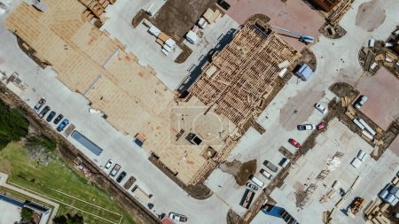 Straight aerial view multistory apartment complex under construction timber wood frame, elevator vertical shaft, large courtyard, slab foundation, worker heavy equipment, downtown Dallas, Texas. USA