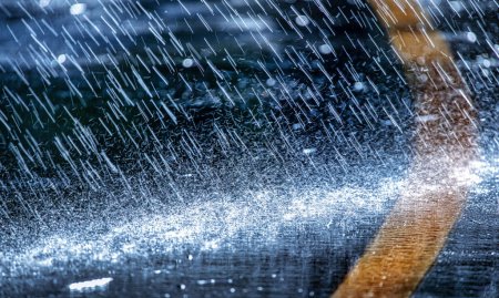 Téléchargez les photos : Raindrops fall on the asphalt. Deterioration of weather conditions. Precipitation, cooling. - en image libre de droit
