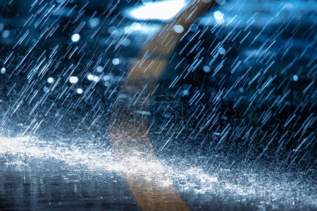 Téléchargez les photos : Raindrops fall on the asphalt. Deterioration of weather conditions. Precipitation, cooling. - en image libre de droit