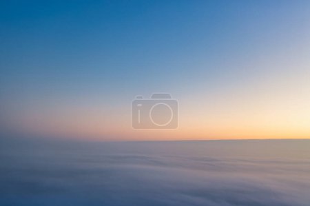 Téléchargez les photos : Sunrise above the clouds. Flying in the sky. A wonderful morning or evening landscape. Abstract natural background. - en image libre de droit