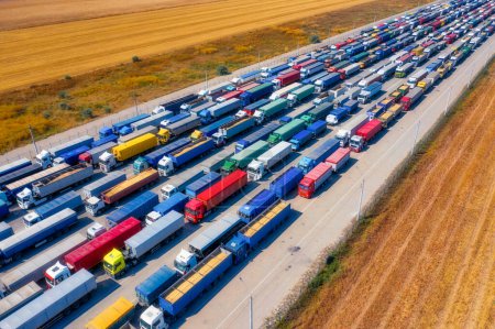 Téléchargez les photos : Activité d'exportation de céréales animée en Ukraine, avec une mer de camions transportant du grain près du port - en image libre de droit