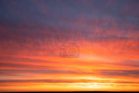 Téléchargez les photos : Le ciel est embrasé de couleurs vives sur cette superbe photo. Les nuages reflètent l'éclat chaud du soleil couchant, créant une image enflammée et captivante - en image libre de droit