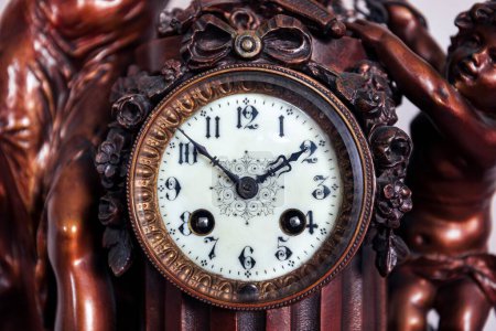 Ein Frontporträt des Retro-Zifferblatts einer alten Vintage-Uhr aus Holz und Metall mit schönen Uhrzeigern und Ziffern zur Zeitanzeige. Es ist zehn vor zwei.