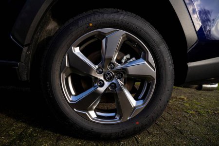 Photo for Brecht, Belgium - 5 february 2022: A portrait of a toyota rav 4 wheel, rim and tire with the logo in the middle standing on a drive way. - Royalty Free Image