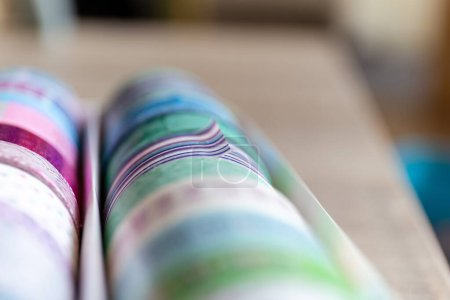 Foto de Un retrato de cinta washi colorida en diferentes patrones y colores en una caja. Los rollos decorativos están listos para usar para decorar una tarjeta de regalo, regalo o postal o para usar para el diseño de interiores como en una pared.. - Imagen libre de derechos