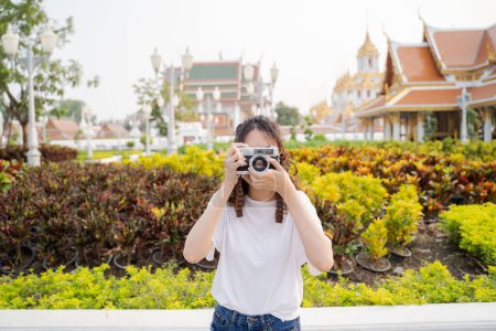 Photo for Asian woman tourist backpacker smiling, traveling and taking photo with temple background in Bangkok, Thailand. Asian people excited and having fun traveling. - Royalty Free Image