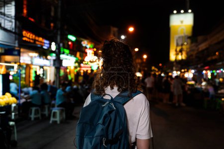 Photo for Back of female solo hipster traveller walking on street in Bangkok, Thailand. Female tourist exploring Southeast Asia. - tourism and travel destination concept - Royalty Free Image