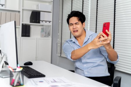 Téléchargez les photos : Homme d'affaires asiatique en colère crié, grondé, s'est plaint sur le téléphone portable pour dans le cadre de la salle de bureau. - Lutte des entreprises et conflits sur le lieu de travail - en image libre de droit