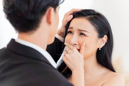 Photo for Emotional Asian bride tears up in tender moment with groom at their wedding ceremony. Heartfelt emotions as a woman cries with joy at her wedding. - Royalty Free Image