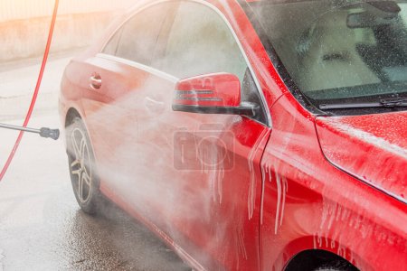Téléchargez les photos : Lavage de voiture rouge avec portes latérales à jet de pression et rétroviseur - en image libre de droit