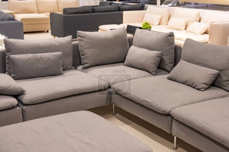 Téléchargez les photos : Showroom dans le magasin de meubles rembourrés grand avec canapés. Un exemple de pièce aux tons pastel pour canapés d'angle - en image libre de droit