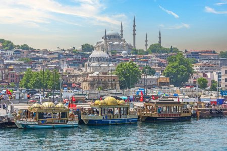 Photo for View of the central historical part of Istanbul with old buildings and a large mosque on a hill, traditional decorative boats and piers, ships and ferries with people floating in the Bosphorus - Royalty Free Image