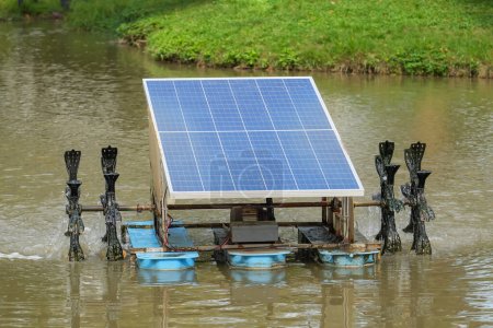 Téléchargez les photos : Aérateur de roue de palette de panneau de cellule solaire dans l'étang de parc de ville. - en image libre de droit