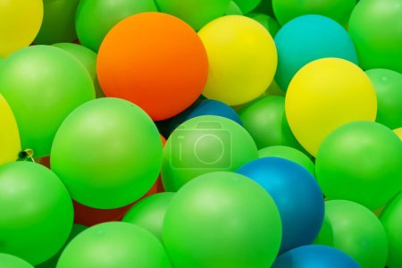 Ballons gonflables en caoutchouc jaune vert orange bleu texture rapprochée.