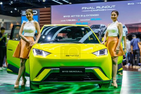 Téléchargez les photos : BYD Seagull couleur vert clair est une voiture électrique sous-compacte d'une société chinoise avec deux beaux modèles de filles. Thaïlande, Bangkok 07 avril 2024. - en image libre de droit