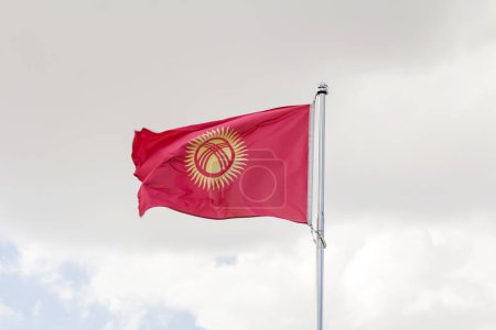 Waving flag of Kyrgystan against sky