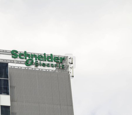 Téléchargez les photos : Bucarest, Roumanie - 12 juin 2022 : Un logo de Schneider Electric, spécialiste mondial de la gestion de l'énergie et de l'automatisation, est affiché sur le toit d'un bâtiment, dans le quartier "Pipera". - en image libre de droit