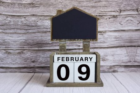 Photo for Chalkboard with calendar date on white cube block on wooden table. - Royalty Free Image