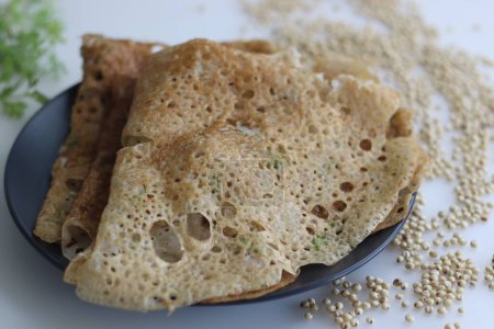 Photo for Crispy, golden Instant Jowar dosa. Quick and easy Indian breakfast dish, made with jowar flour by mixing it with water and cooked on a preheated non stick pan. Healthy, gluten free and high in fibre - Royalty Free Image