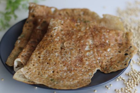 Photo for Crispy, golden Instant Jowar dosa. Quick and easy Indian breakfast dish, made with jowar flour by mixing it with water and cooked on a preheated non stick pan. Healthy, gluten free and high in fibre - Royalty Free Image