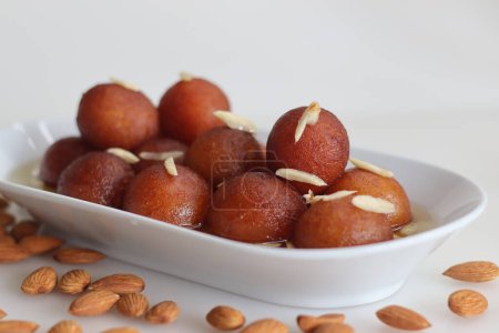 Téléchargez les photos : Gulab jamun. A milk solid based sweet popular in Indian subcontinent. Soft deep fried delicious berry sized balls made with milk solids, all purpose flour and soaked in cardamom flavoured sugar syrup - en image libre de droit