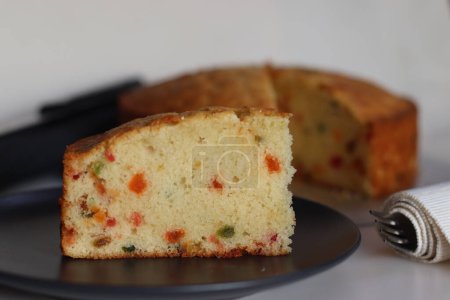 Photo for Sliced Tutti fruity buttermilk cake. A type of Indian fruit cake made with tutti frutti or candied fruits, all purpose flour, sugar, buttermilk and vanilla essence. Shot on white background - Royalty Free Image