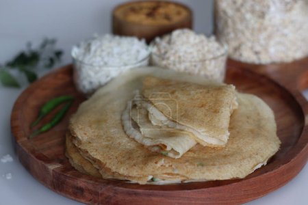 Photo for Instant oats poha dosa served with spicy coconut condiment. Non fermented thin instant crepe recipe made of oats, flattened rice and yogurt. An instant version of favourite Indian dish called dosa - Royalty Free Image