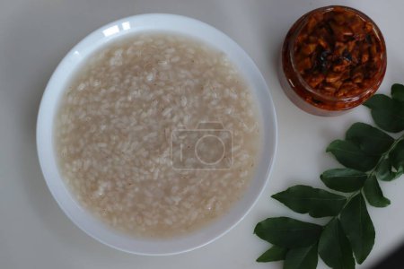 Téléchargez les photos : Kanji et Kadumanga. Gruau de riz préparé avec du riz Kerala Matta. Tourné avec le style Kerala coupé cornichon de mangue sur un fond blanc. - en image libre de droit