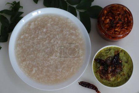 Téléchargez les photos : Kanji et Kadumanga. Gruau de riz préparé avec du riz Kerala Matta. Servi avec du curry de banane cru et du cornichon de mangue coupé au Kerala. Tourné sur un fond blanc. - en image libre de droit