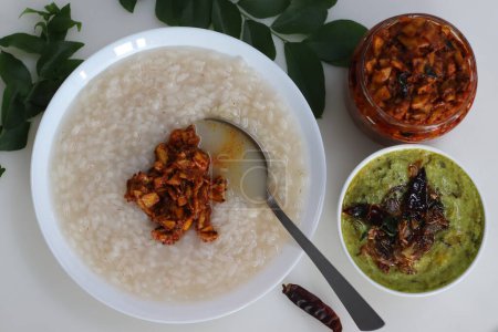 Téléchargez les photos : Kanji et Kadumanga. Gruau de riz préparé avec du riz Kerala Matta. Servi avec du curry de banane cru et du cornichon de mangue coupé au Kerala. Tourné sur un fond blanc. - en image libre de droit