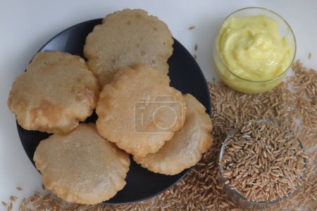Photo for Khapli wheat puris. Deep fried Indian flatbread made of emmer wheat flour served with shrikhand, sweetened yogurt popular in India. A version of puri with oldest wheat varieties of India - Royalty Free Image
