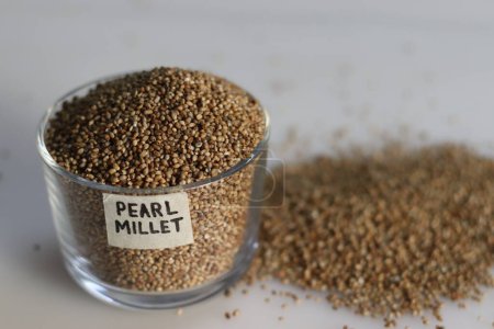 Photo for Pearl millet grains in a glass bowl with label on it filled to the brim, showcasing their pearl like natural beauty and healthy nutrition. Ideal for food and agriculture concepts - Royalty Free Image