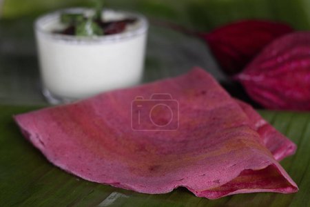 Photo for Beetroot ghee roast. A colorful, flavorful South Indian Crispy crapes made with fermented batter of rice and lentils mixed with beetroot. Served on banana leaf along with coconut green chilly chutney - Royalty Free Image