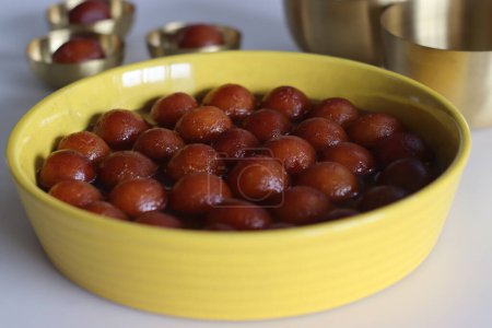Photo for Delectable Gulab Jamun dessert on a rustic plate. Close up of golden fried milk balls in sweet syrup. Indian sweets, traditional delicacy. Festive, delicious, indulgent celebration confectionery - Royalty Free Image